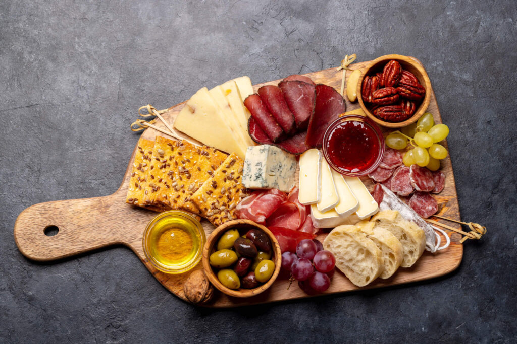various meats and cheeses on a bamboo board