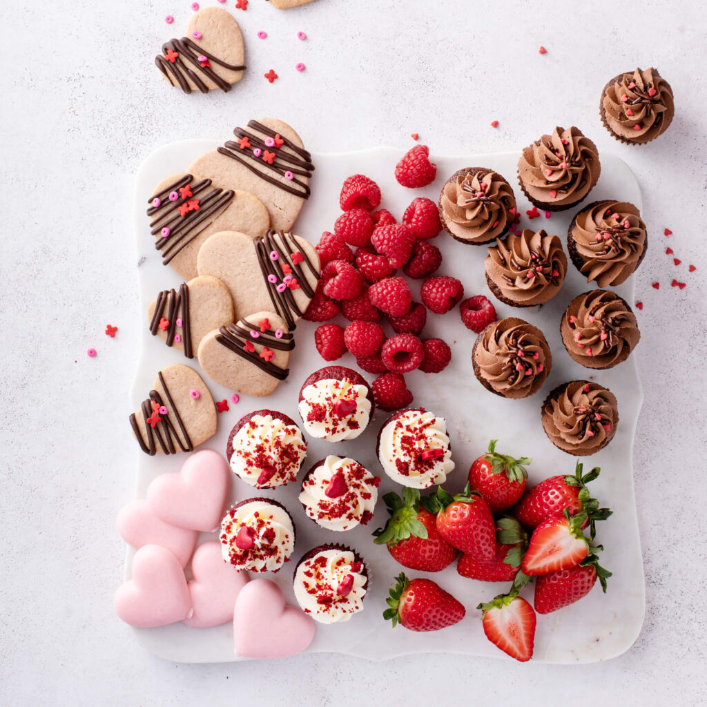 cupcakes, strawberries and raspberries on a board