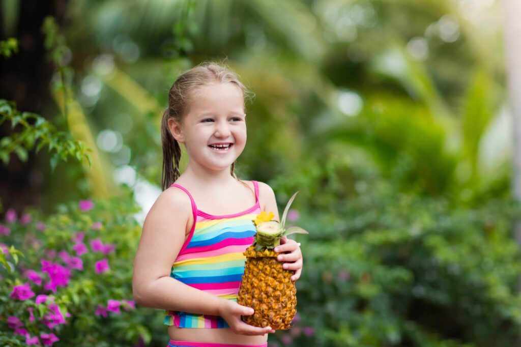 girl drinking a tropical drink in a pineapple