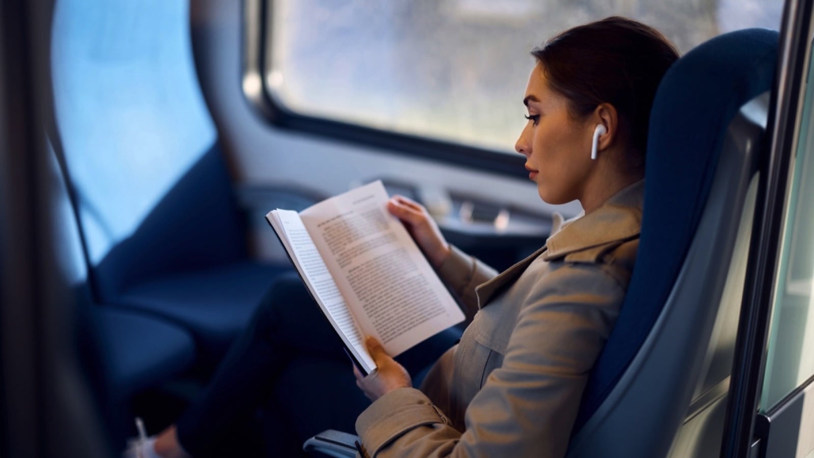 Woman traveling in train reading book